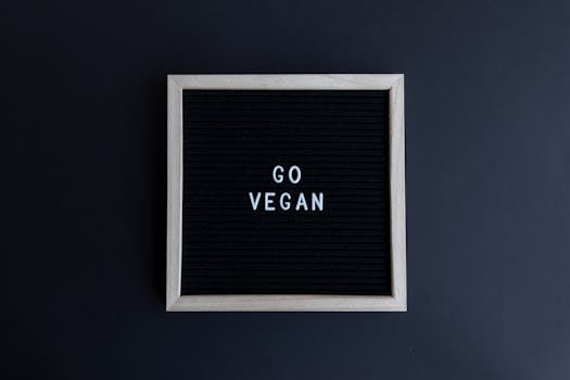 Simple wooden framed board displaying the motivational text 'Go Vegan' on a dark background.