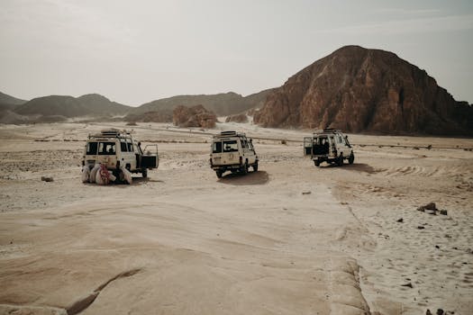 Three off-road vehicles traverse a rocky desert, emphasizing adventure and exploration.